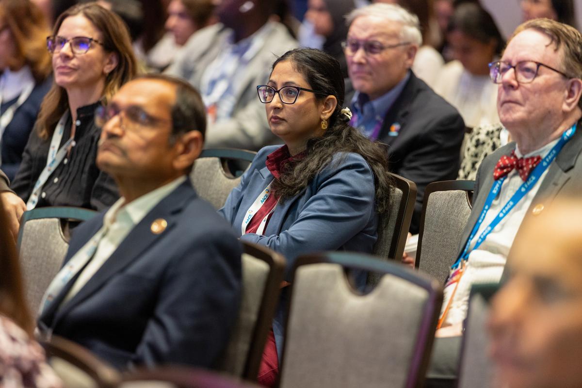 Attendees sitting in audience listening to a lecture. 
