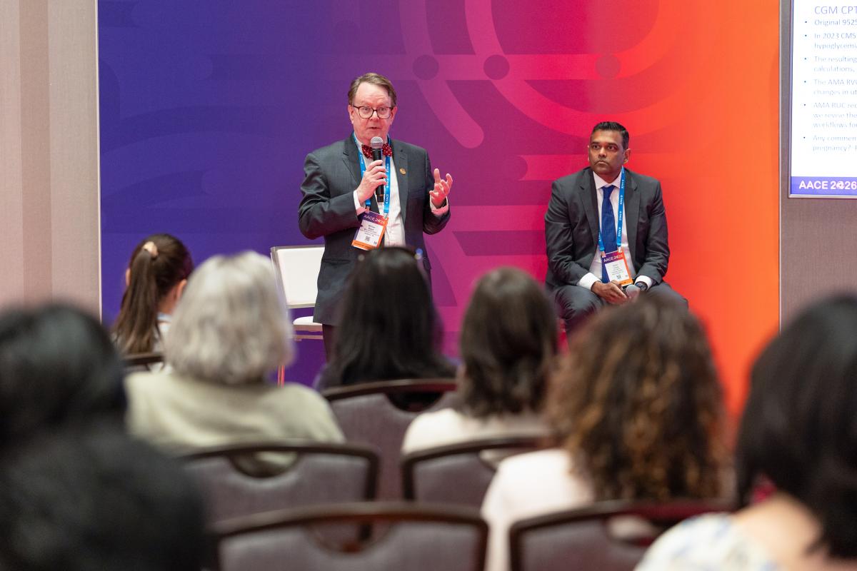 Presenter talking in front of an audience. 
