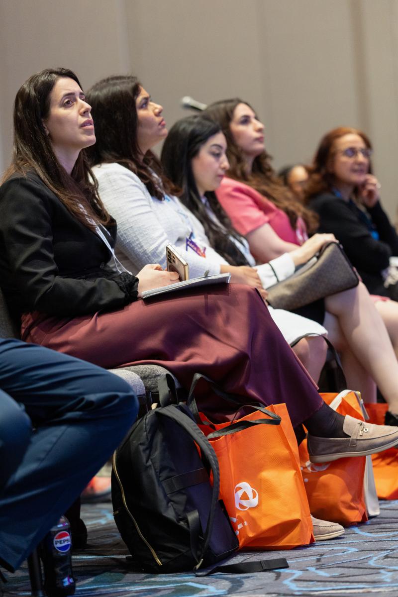 Group of attendees in audience listening to lecture. 