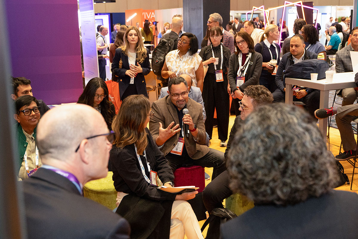 Attendees sitting in a circle chatting in the Learning Zone. 