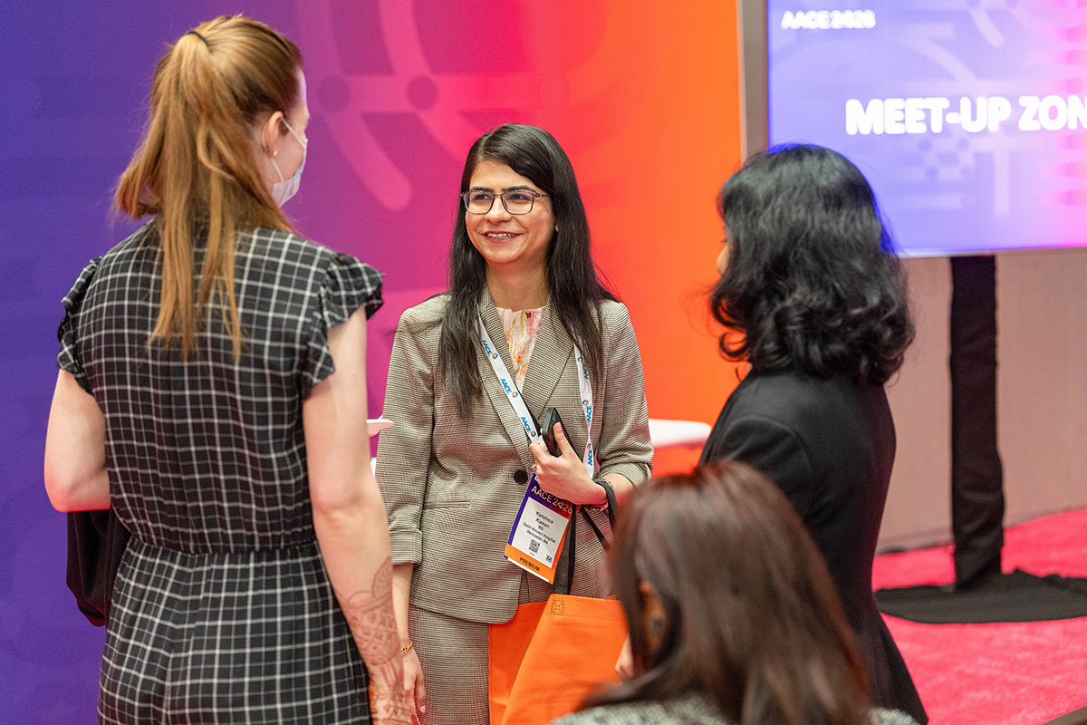 Three attendees talking in the Meet-Up Zone. 