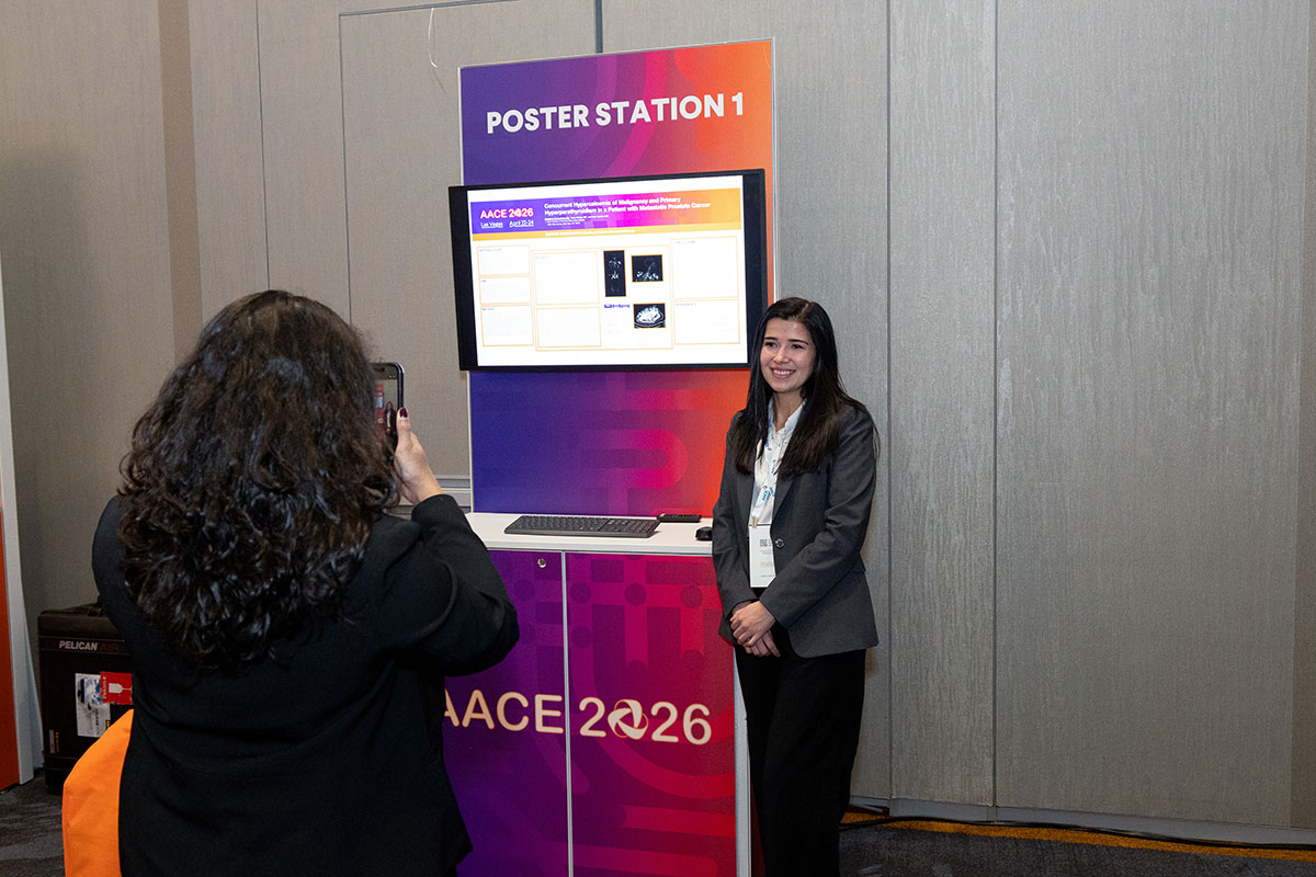 Attendee presenting in front of digital poster. 